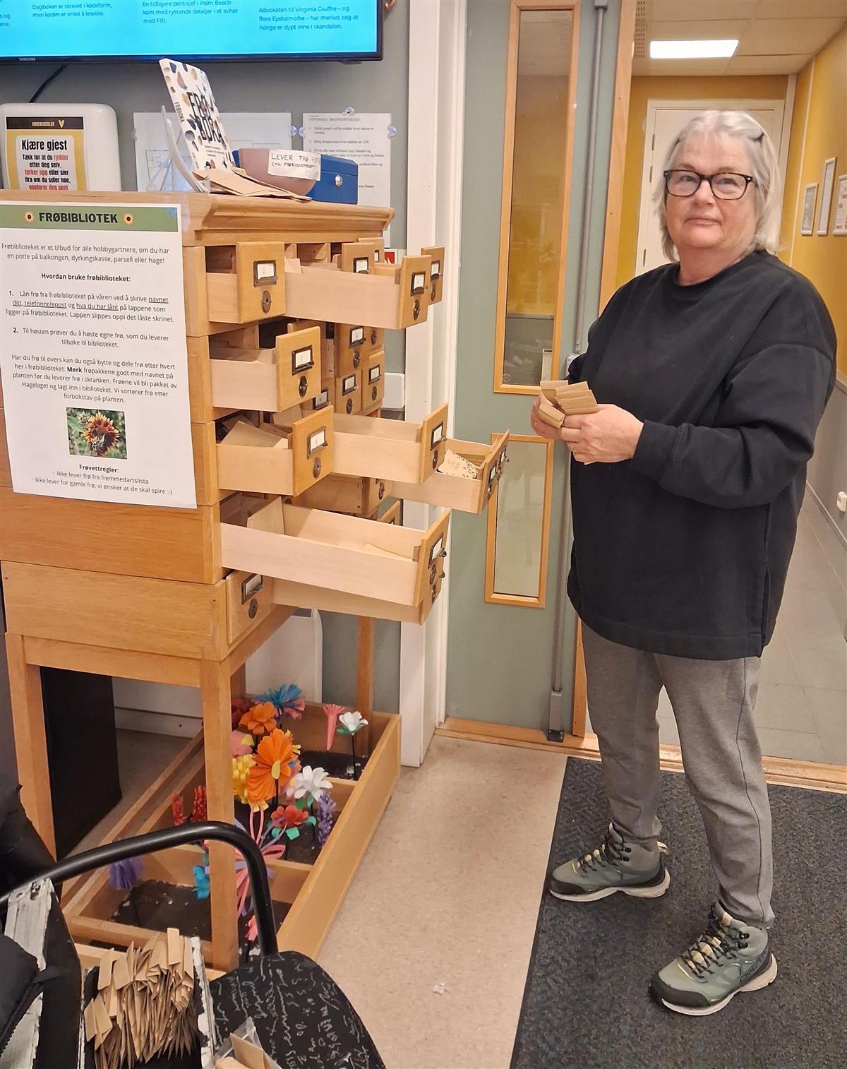 Bilde av Grethe fra Hagelaget foran frøbiblioteket i biblioteket. - Klikk for stort bilde